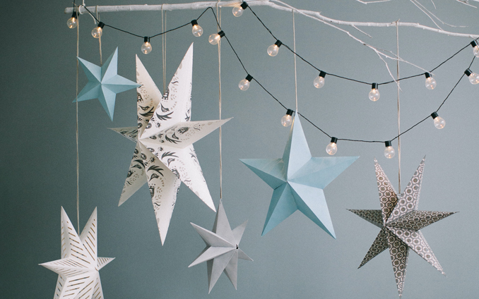 Paper stars and fairy lights hang from a suspended white-painted branch, Photo by Lina Kivaka on Pexels.com